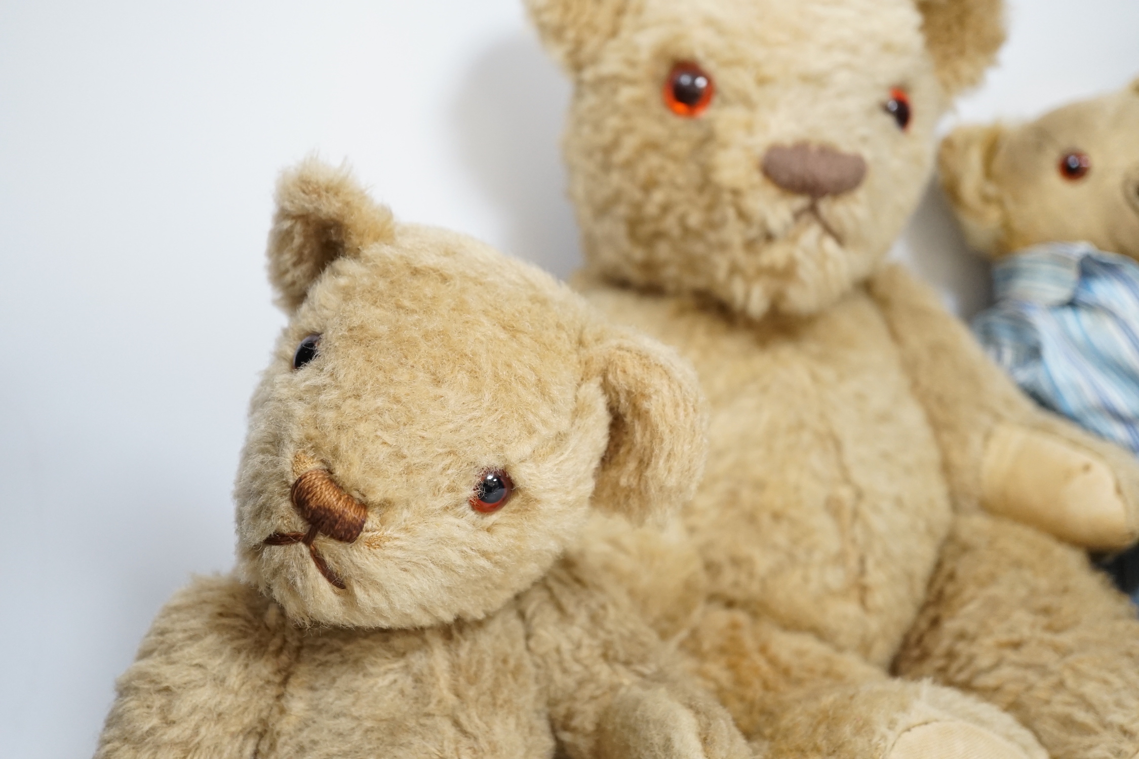 Two Invicta bears, 30cm and 45cm, some wear, and a Merrythought bear, dressed in vintage dressing gown and pyjamas, 32cm high, with hair loss